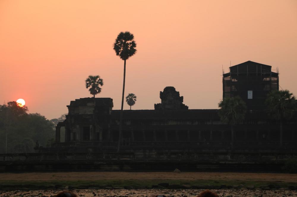 Angkor Wat at sunrise.  The largest religious complex in the world,  the outer wall is 15 feet high and 3300 x 2600 feet long.  Surrounded by a 600 foot wide mote helped protect it from jungle enchroachment